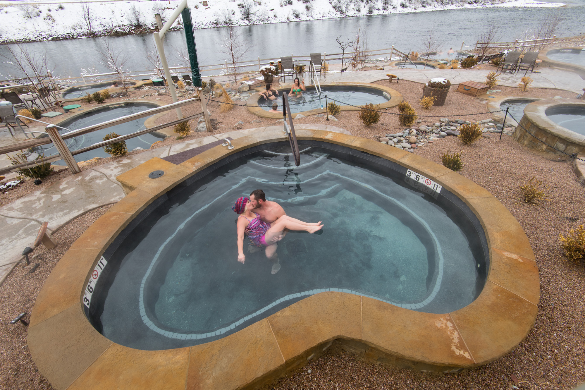 couple in heart shaped pool during winter time at iron mountain hot springs